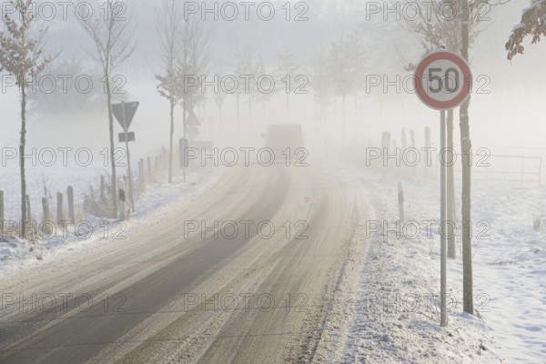 Wintertag, Straße mit Schneematsch bedeckt, Auto im Nebel, Nordrhein-Westfalen, Deutschland