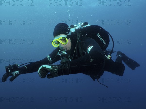 Ein Taucher in voller Ausrüstung kontrolliert unter Wasser seinen Tauchcomputer. Tauchplatz Wrack der Giuseppe Dezza, Pula, Kroatien, Mittelmeer