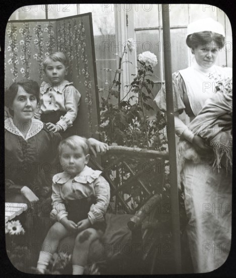 Affluent Edwardian family group indoors with children, mother, nursemaid, UK 1900 - 1930s