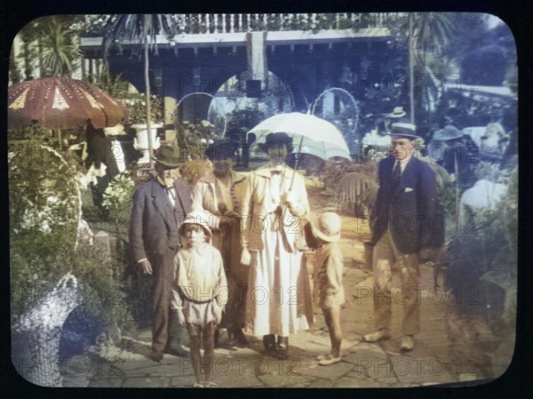 Family group standing in pleasure gardens at Karsino of Fred Karno, Tagg's Island, Molesley, London, England, UK 1920s or 1930s colourised