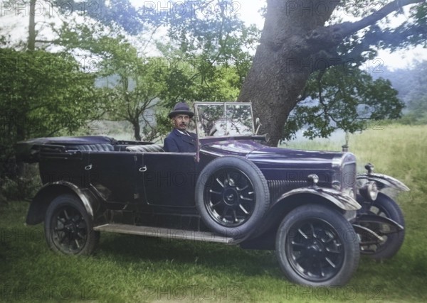 Vintage Sunbeam motor car with driver at wheel in rural setting, England, UK 1920s or 1930s colorised version