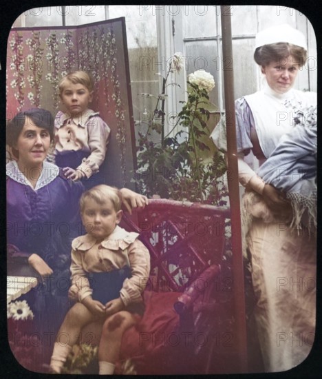 Affluent Edwardian family group indoors with children, mother, nursemaid, UK 1900 - 1930s colourised