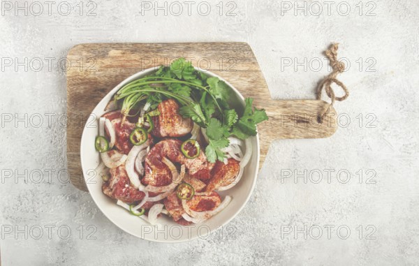 Raw meat marinated with spices and onions, for barbecue, sliced meat, pork neck, in a bowl, homemade, no people