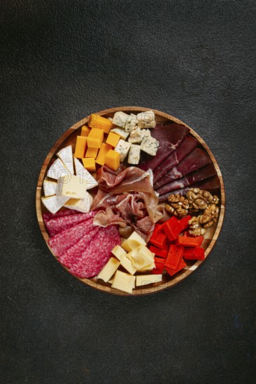 Assortment of cheese meat cuts, on a plate, top view, no people