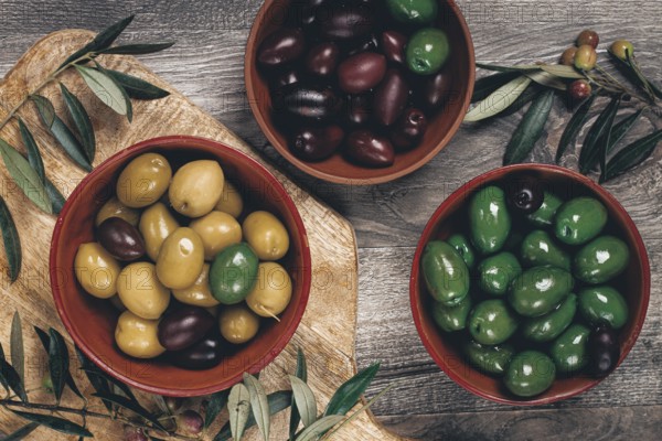A mixture of olives, varieties of chalkidiki, Verdi giganti and Kalamata, in a bowl, top view, no people