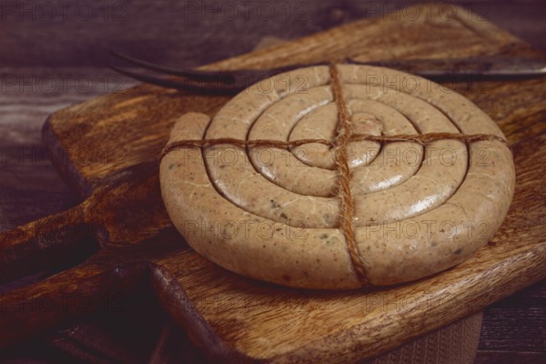Raw spiral sausages, on a wooden board, top view, no people