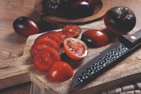 Sliced tomatoes, Black Beauty variety, on a cutting board, top view, on the kitchen table