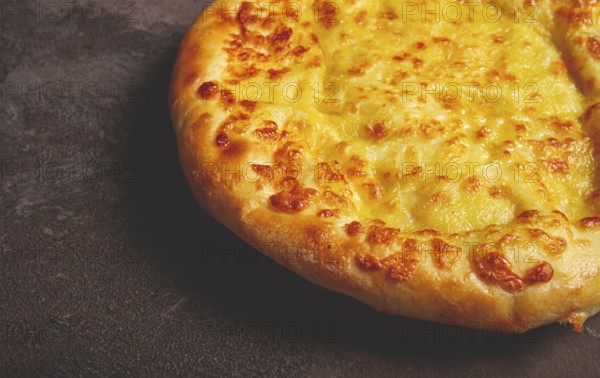 Khachapuri in Megrelian, a traditional Georgian dish, flatbread with cheese, top view, no people