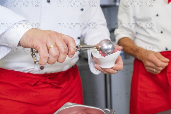 Person serves ice cream in a container with a scoop