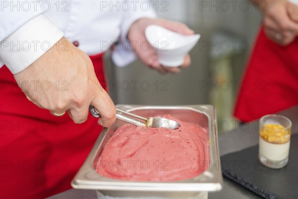 Ice cream is removed from a container with a portioner