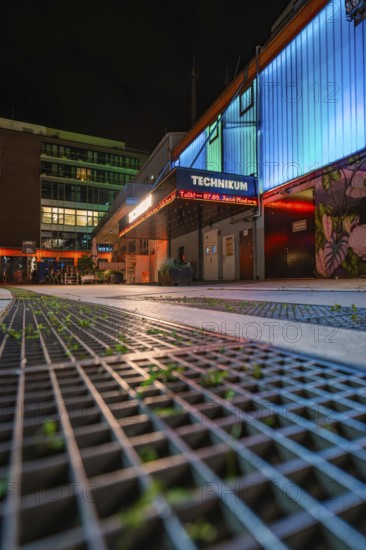 Illuminated urban scene at night with modern buildings and coloured neon lights, Tesla Model Y Juniper, Gechingen, Black Forest, Germany