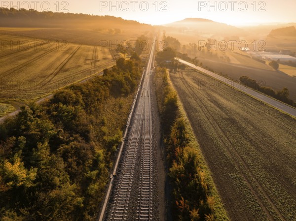 Railway tracks cutting through a rural landscape at sunrise, Hermann Hesse railway, Ostelsheim, Black Forest, Germany