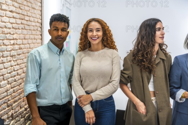 Group of multi ethnic business professionals standing together in a contemporary office, showcasing teamwork, inclusion, and the vibrant atmosphere of a modern startup