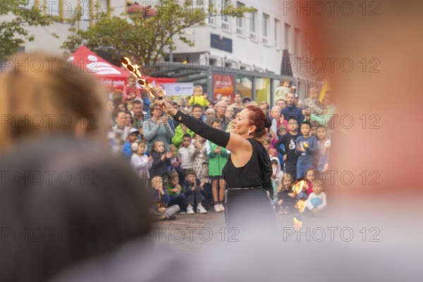 Artist raises torches in the air while many people watch with excitement, Fire Night, Sindelfingen, Germany