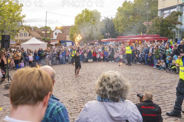 Artist performs a fire show in front of a large crowd at a city festival, Feuernacht, Sindelfingen, Germany