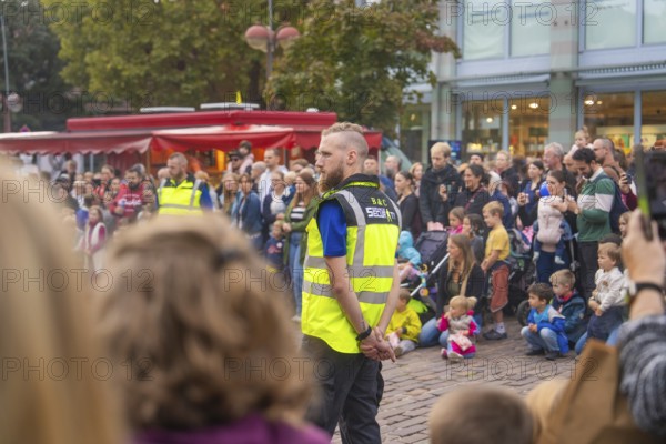 A security guard monitors an event with a gathered crowd, Fire Night, Sindelfingen, Germany