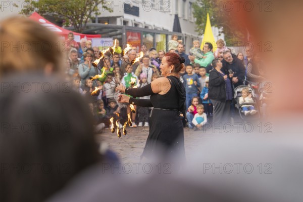 Fire dancer holds up burning torches while the audience looks on, Feuernacht, Sindelfingen, Germany