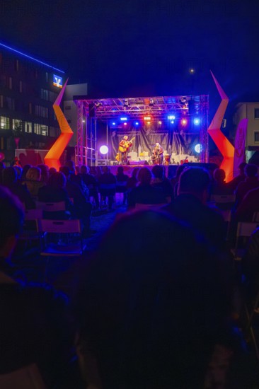 Concert at night on a colourfully illuminated open-air stage with audience, Feuernacht, Sindelfingen, Germany