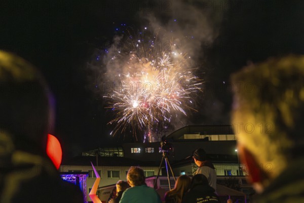 People marvelling at fireworks in the night sky above buildings, Fire Night, Sindelfingen, Germany