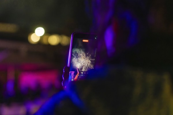 Person looking at fireworks on a smartphone at night, Fire Night, Sindelfingen, Germany