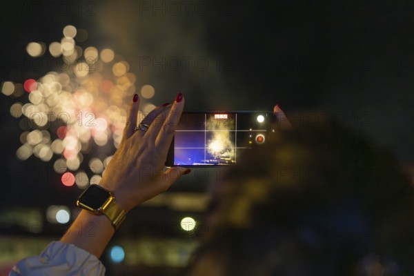 Hand films fireworks with smartphone outdoors at night, Fire Night, Sindelfingen, Germany