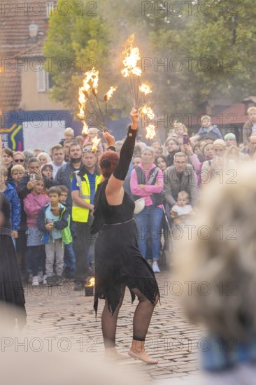 An artist performs a show with fire torches in front of a curious crowd, Feuernacht, Sindelfingen, Germany