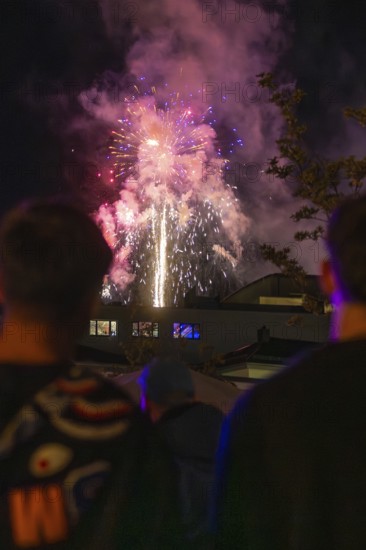 People watching fireworks in the night sky with coloured lights, Fire Night, Sindelfingen, Germany