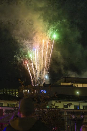 Colourful fireworks light up the night sky, smoke drifts through the air and people watch enthusiastically, Fire Night, Sindelfingen, Germany