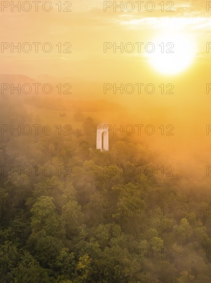 A lone tower rises out of a misty forest, illuminated by a warm sunset, Schönbergturm, Pfullingen, Swabian Alb, Germany