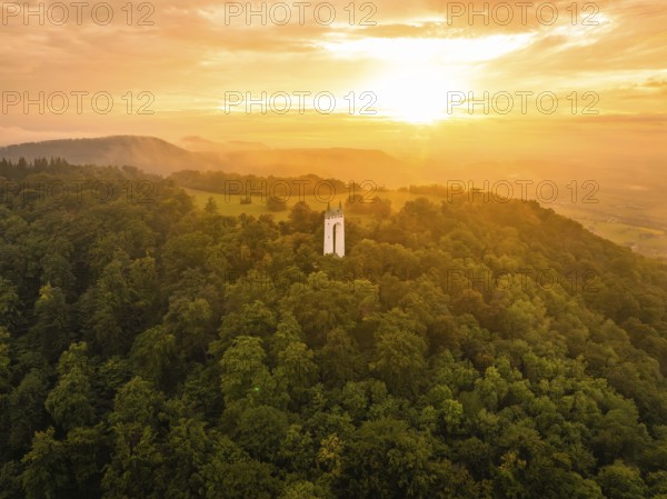 A white tower stands in a forest at sunset in the soft light, Schönbergturm, Pfullingen, Swabian Alb, Germany