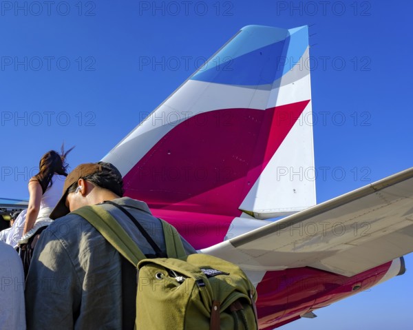 Mykonos, Greece - EUROWINGS. At Mykonos Airport, holidaymakers board a Eurowings aircraft via an external staircase on the apron