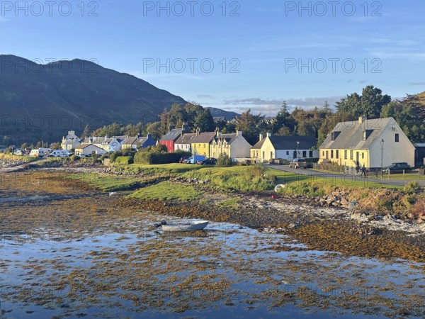 Coastal landscape with charming colourful houses and a small boat in the evening light, Dornie, Scotland, Great Britain