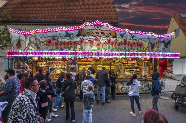 Shooting gallery in the evening at the church fair in the village of Eschenau, Middle Franconia, Bavaria, Germany