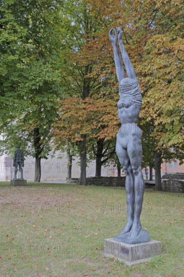Sculpture Große Neeberger Figur von Wieland Förster 1997, nude standing female figure, nude, undress, undressing, clothes, over, head, covered, up, without, arms, high, up, stretching, bronze sculpture, modern art, sculpture park, Magdeburg, Saxony-Anhalt, Germany