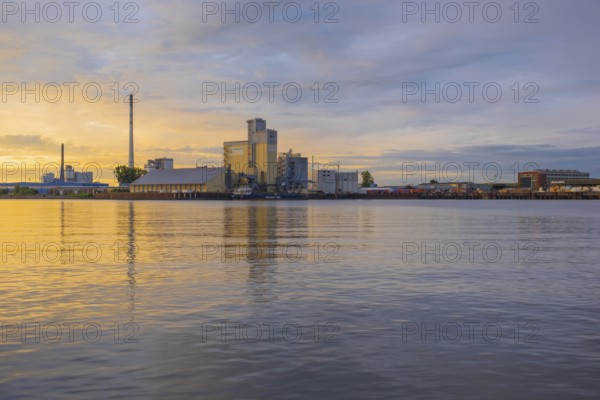 View across the Weser to an industrial area in the evening light, Gröpelingen, Bremen, Germany