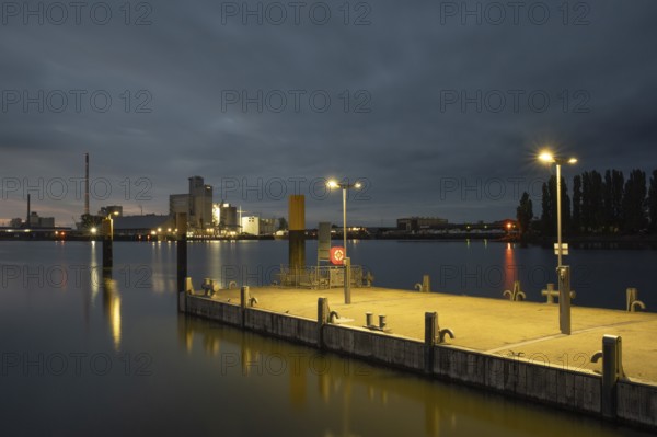 View of a mooring pontoon on the Weser at Lankenauer Höf in the background an industrial area in the evening light, Gröpelingen, Bremen, Germany