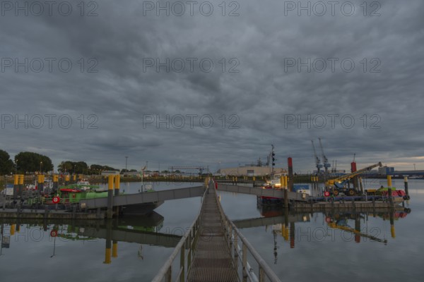 View along a jetty from which further jetties branch off leading to pontoons and ships, Neustädter Hafen, evening light, Weser, Bremen, Germany