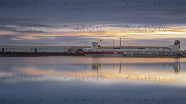 View of a ship moored at the quay in Neustadt harbour at sunset, long exposure, Weser, Bremen, Germany