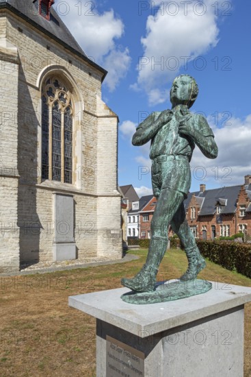 Statue Anzie Seppe, chiro boy in front of the Sint-Petruskerk, Saint Peter's Church in the village Bazel near Kruibeke, East Flanders, Belgium