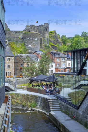 Tourists at restaurant along the river Ourthe and ruined castle in the city La Roche-en-Ardenne, province of Luxembourg, Ardennes, Wallonia, Belgium
