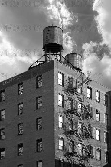 High-rise residential building with wooden water tanks on the roof, black and white, New York City, USA