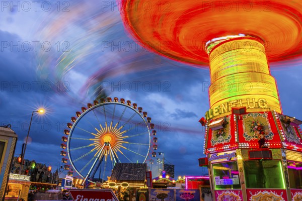 Illuminated chain carousel in motion, behind the Ferris wheel at standstill, Festwiese, Theresienwiese, Oktoberfest, Munich, Upper Bavaria, Bavaria, Germany