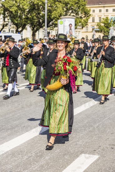 Marketender with flower-decorated cornucopia in front of the brass band from Aschheim, traditional traditional costume and rifle parade, Oktoberfest, Munich, Upper Bavaria, Bavaria, Germany