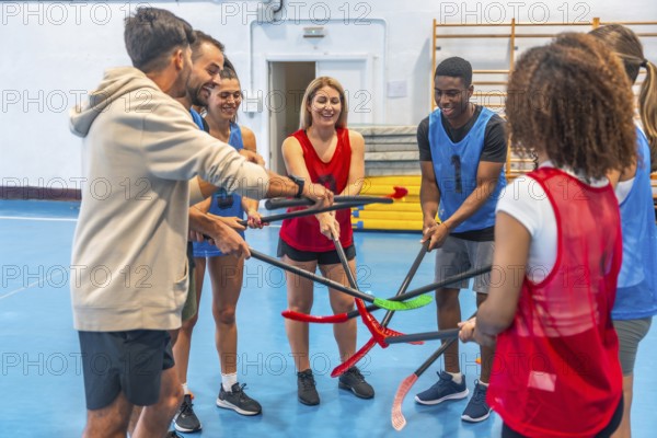 Floorball players gathering their sticks in a circle before a match, smiling and displaying teamwork and sportsmanship in a vibrant gym setting, embodying unity and enthusiasm