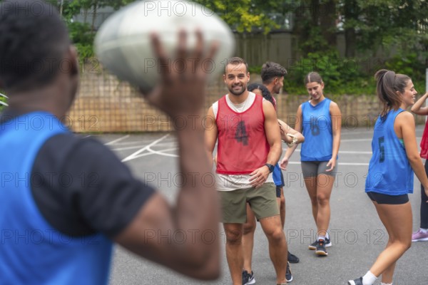 Group of athletes in sportswear engaging in passing drills while training on an outdoor court, showcasing teamwork, skill, and dedication to improving their rugby game