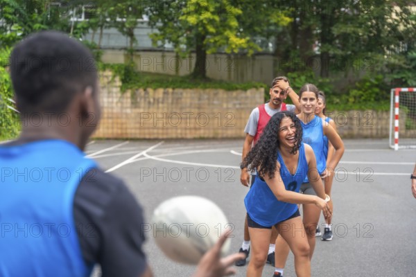 Diverse group of multi ethnic rugby players enjoying training on an outdoor court, passing the ball with enthusiasm and showcasing the joy of teamwork and camaraderie in the sport