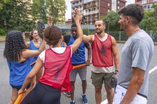 Diverse baseball players in colorful uniforms celebrating a successful play with enthusiastic high fives on the field while their coach observes with a clipboard