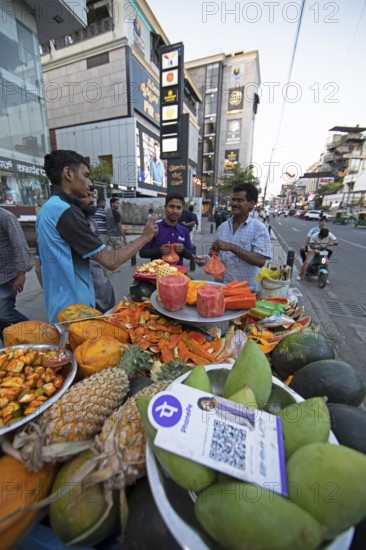 Indian men buying fresh fruit at a roadside stall, Begaluru or Bangalore, Karnataka, India