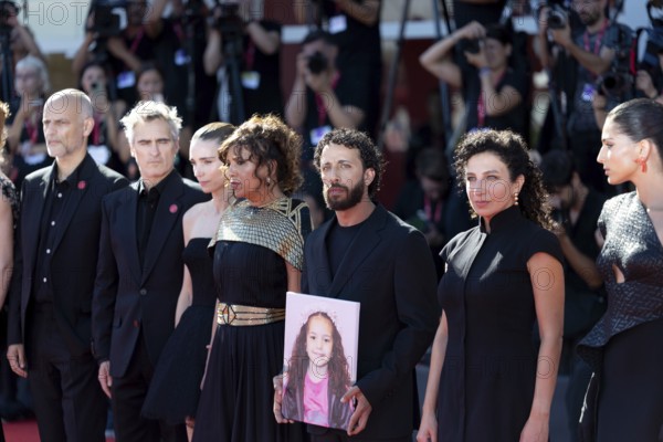 Venice, Italy - 3 September 2025: Motaz Malhees with a portrait of five-year-old Palestinian girl Hind Rajab, who was killed by the Israeli army in the Gaza Strip in January 2024, during the red carpet of - The Voice Of Hind Rajab - during the 82nd Venice International Film Festival