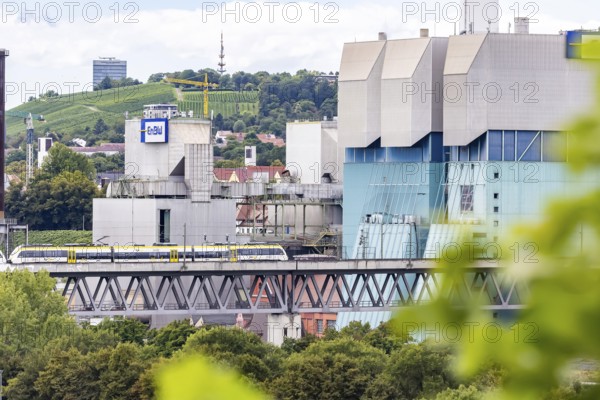 SWEG regional train travelling on the Schusterbahn, Münster viaduct with EnBW Energie Baden-Württemberg combined heat and power plant. Stuttgart, Baden-Württemberg, Germany